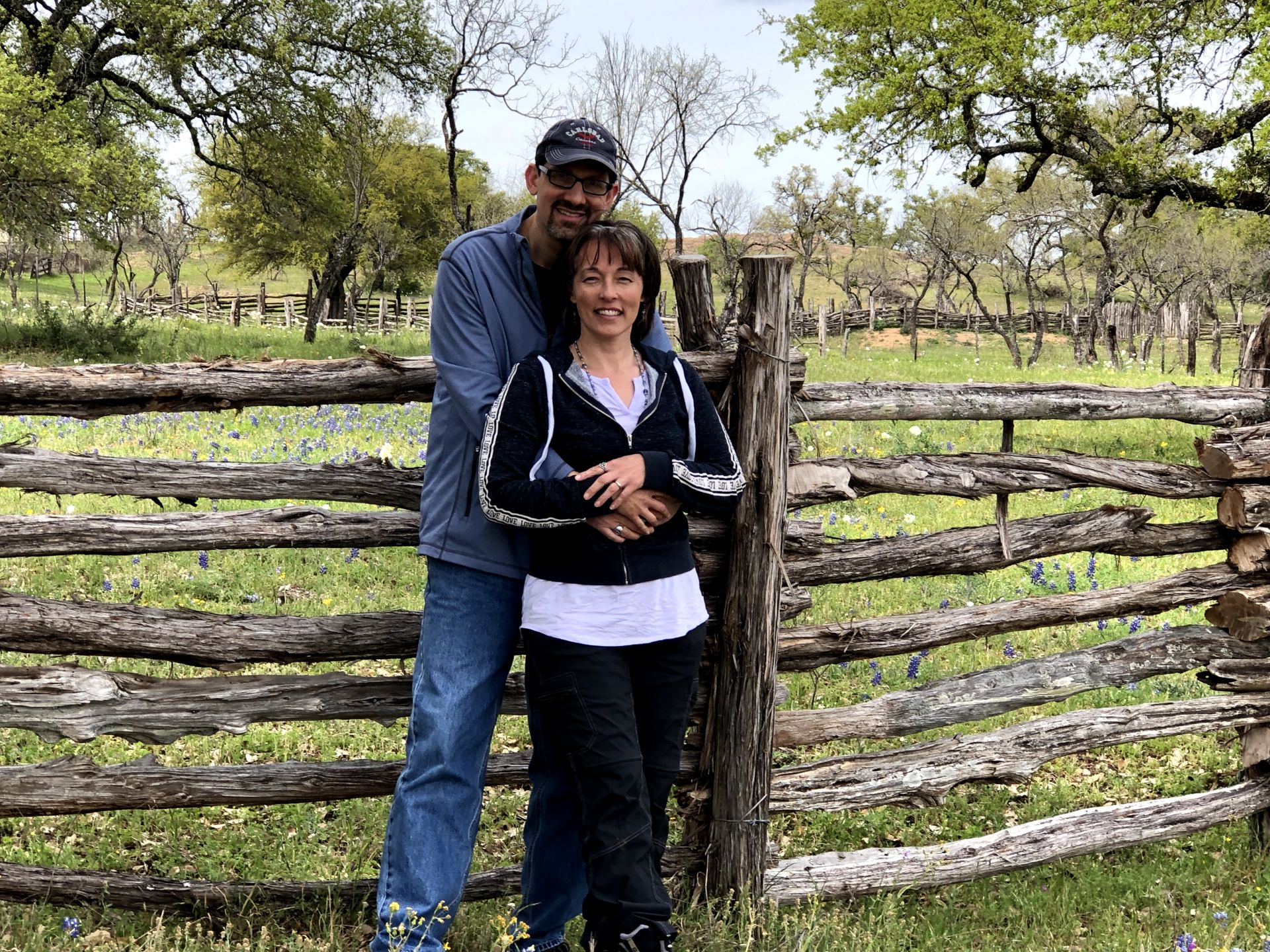 Couple standing in front of split rail fence